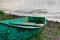 Old boats made of wood and metal on the river Bank among rocks and vegetation. Parked water transport in nature.