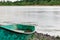 Old boats made of wood and metal on the river Bank among rocks and vegetation. Parked water transport in nature.