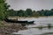 Old boats made of wood and metal on the river Bank among rocks and vegetation. Parked water transport in nature.