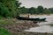 Old boats made of wood and metal on the river Bank among rocks and vegetation. Parked water transport in nature.