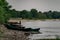 Old boats made of wood and metal on the river Bank among rocks and vegetation. Parked water transport in nature.