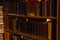 Old books stand on wooden shelves, shelving with books.on the shelf is an old, rusty lock and a bunch of keys, the concept of scie