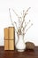 Old books, vase with twigs and thread