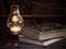 Old books on a wooden table, antique lamp