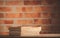 Old books on wooden table at brick wall