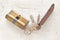 Old brass cartridge cylinder with keys on white wooden background