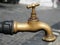 Old brass tap or faucet in a street close up