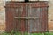 An old brick non-residential building. An ancient historical building. Unusual arched windows and large wooden gates in an ancient