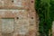 An old brick non-residential building. An ancient historical building. Unusual arched windows and large wooden gates in an ancient