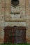 An old brick non-residential building. An ancient historical building. Unusual arched windows and large wooden gates in an ancient