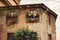 Old brick stone italian house in Bergamo, Italy with flower boxes on windows. Colorful flowers on window with gray cloudy sky on