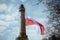 Old Brick Stone Lighthouse with polish national flag