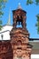 An old brick tower with a crucifix in the form of a bell tower in the wall of the Pokrovskoe-Streshnevo Estate. Moscow.