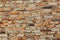 Old brick wall, crooked brown bricks, uneven seams, brickwork collapsed