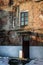 Old brick wall with a door, a window and stairs