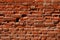 Old brick wall, old texture of weathered red stone blocks closeup