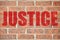 Old brick wall texture with JUSTICE inscription