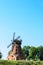 Old brick windmill on field on blue sky background