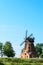 Old brick windmill on field on blue sky background