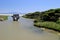 Old bridge on river leading to the sea in sunny Spain