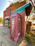 Old british english telephone phone box booth in front of a deserted hotel in a rundown ghost town