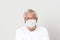 Old British men at risk by coronavirus. Old grey hair guy wearing a face mask for protection against coronavirus. Half body view o