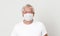 Old British men at risk by coronavirus. Old grey hair guy wearing a face mask for protection against coronavirus. Half body view o