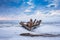 Old broken boat wreck and rocky beach in wintertime. Frozen sea, evening light and icy weather on shore like fairy tale country.