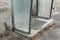 Old broken entrance area of a front door with glass walls and glass roofing, Germany