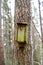 old broken nesting box hanging alone on tree trunk