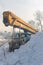 Old broken rusty truck crane with yellow boom covered with snow on a winter day