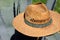 An old broken straw hat hangs on the leaves of an agave, outdoors