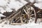 Old broken wagon with wheel in snow
