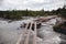 Old, broken, wooden bridge over the river in the Altai mountains. Extreme crossing the river