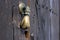Old bronze door handle in the shape of a hand. Brown wooden door of a house in the Spanish city of Ronda