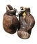 Old brown boxing gloves .