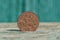 Old brown copper coin stands on a gray table