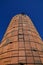 An old brown stone silo with a climbing ladder