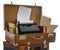 Old brown suitcases with old retro typing machine on white background