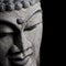 Old Buddha head statue detail on black