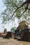 Old Buddha statue in the ancient place with branch of tree in foreground