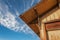 Old building exterior corner looking up at roof, blue sky,