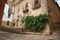 Old building facade with green creeper, on corner of narrow alley at Caceres