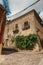 Old building facade with green creeper, on corner of narrow alley at Caceres