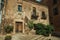 Old building facade with green creeper, on corner of narrow alley at Caceres