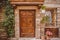 old building with wooden doors and potted plants on street in Castel Gandolfo, Rome