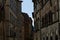 Old buildings inside one of the alleys of the town of Siena