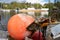 Old buoys loaded with anchors were pulled ashore to be replaced with new ones. The aged red buoys are faded from the water and are