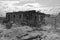 Old burnt house against cloudy sky as black and white image