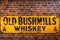 Old Bushmills Whiskey famous for over 300 years sign on rustic brick wall